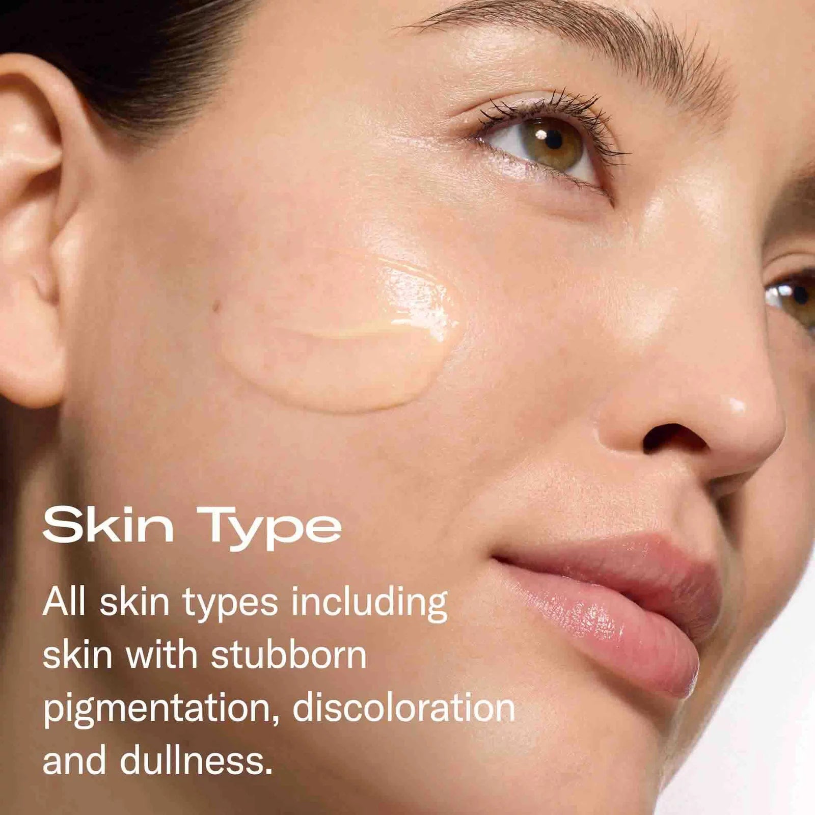 Close-up of a woman's face with a smear of cream makeup on her cheek and overlaid text reading 'Skin Type' and 'All skin types including skin with stubborn pigmentation, discoloration and dullness.'.